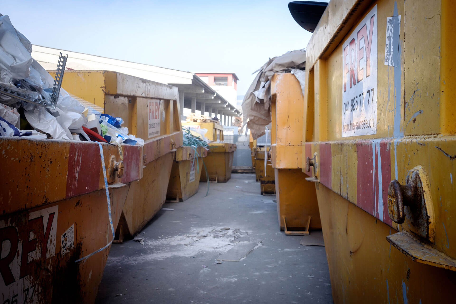 Gelbe Mulden gefüllt mit verschiedenen Recycling-Abfällen.