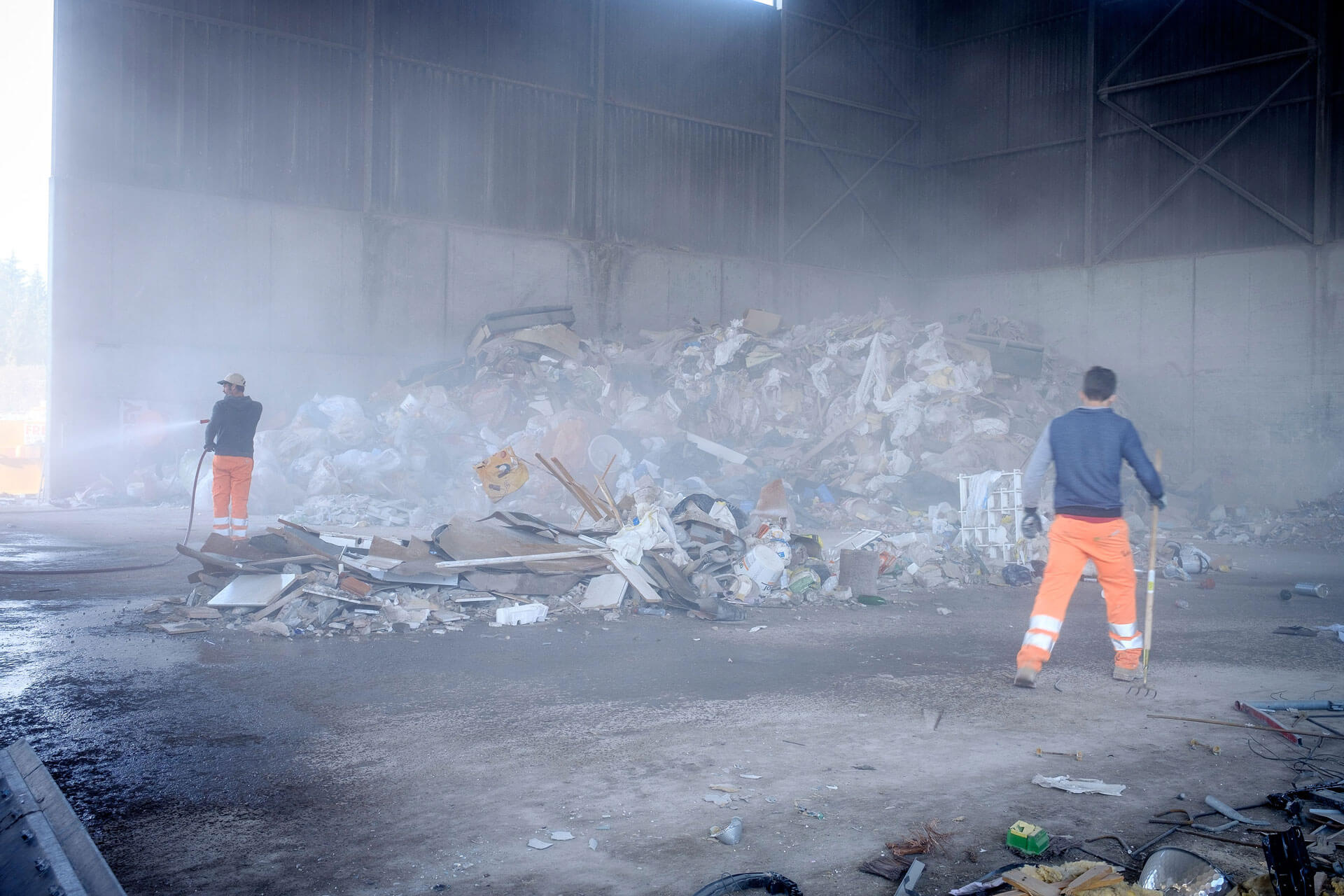 Berg mit Recycling-Abfällen. Zwei Josef Frey AG Mitarbeiter sorgen für Ordnung.