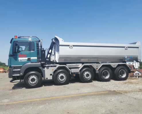 Welaki: 5-Achser Lastwagen von Fehr Transporte mit Abrollkipper SAURIER 32TR80 VARITEC und grauem Container.