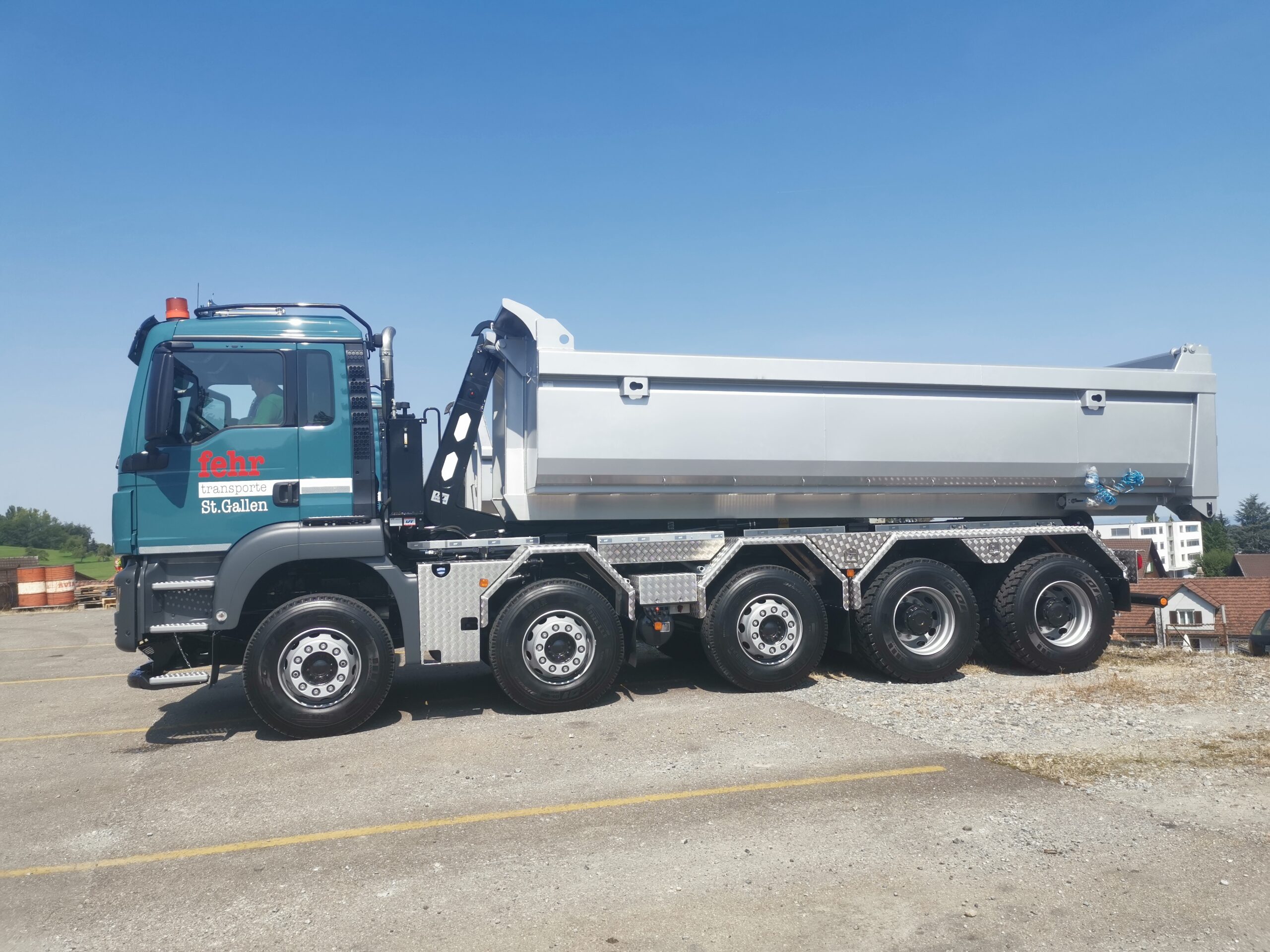 Welaki: 5-Achser Lastwagen von Fehr Transporte mit Abrollkipper SAURIER 32TR80 VARITEC und grauem Container.