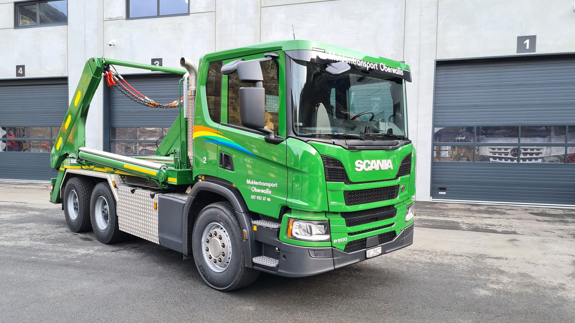 Grüner 3-Achser Lastwagen mit UT Absetzkipper.